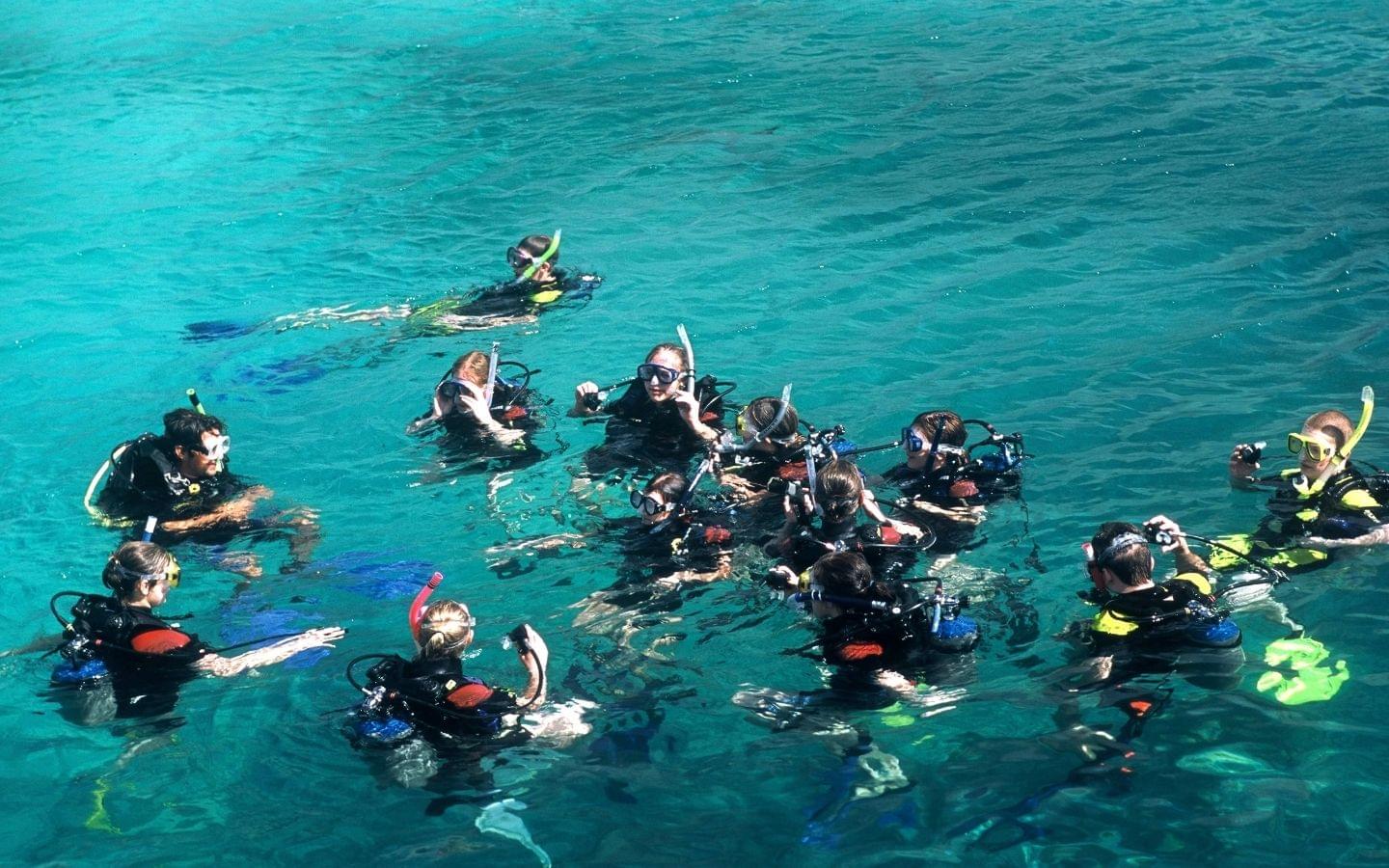 scuba diving instructor leading a group of divers in a lesson