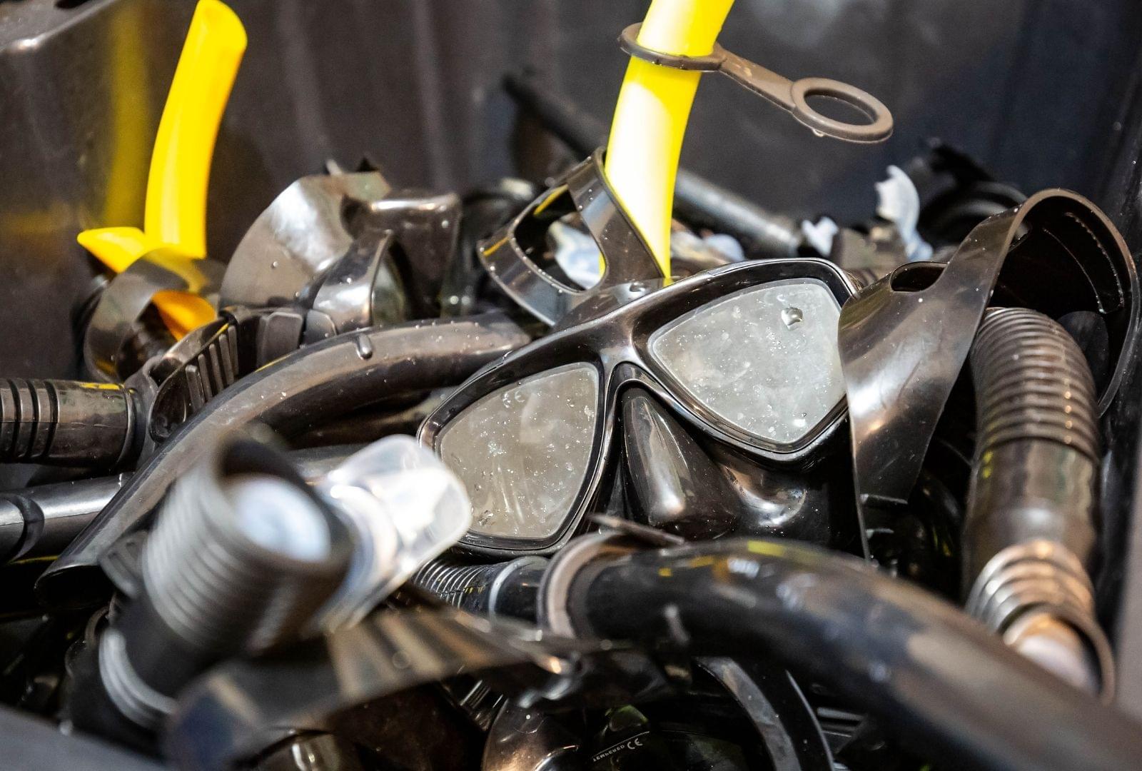 bucket of used snorkeling gear getting cleaned