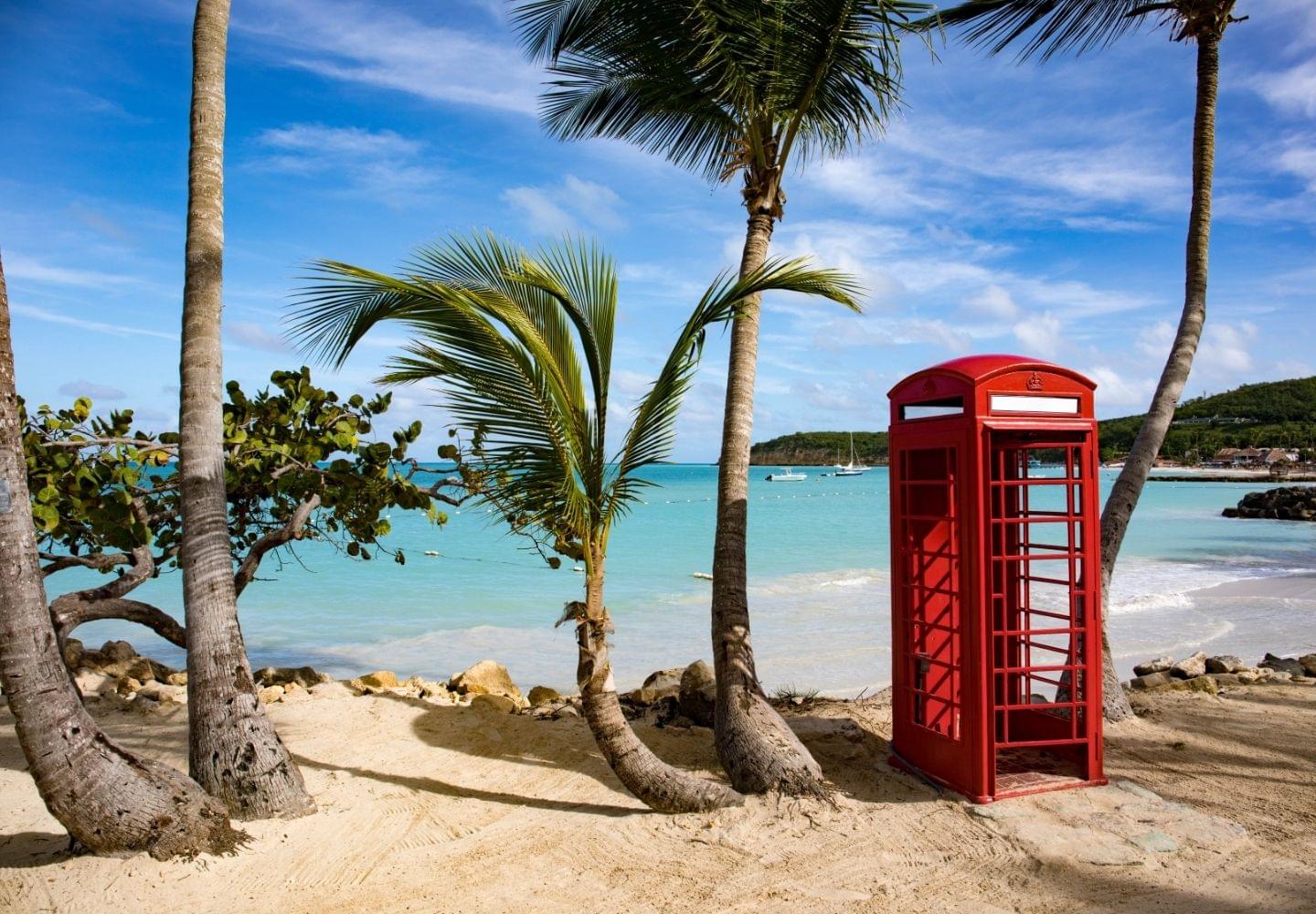 dickenson bay beach with red phone booth