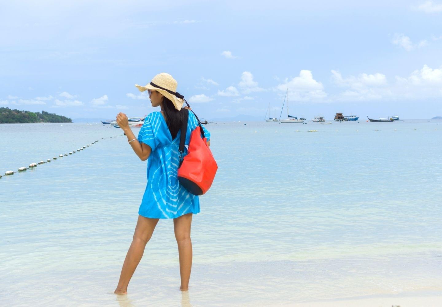 girl in blue dress with waterproof bag on shoulder