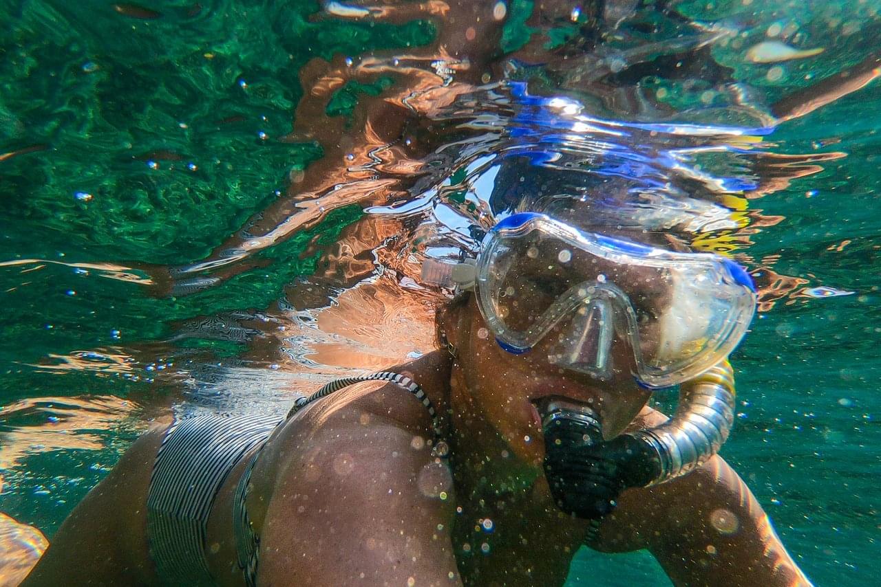 girl snorkeling on surface