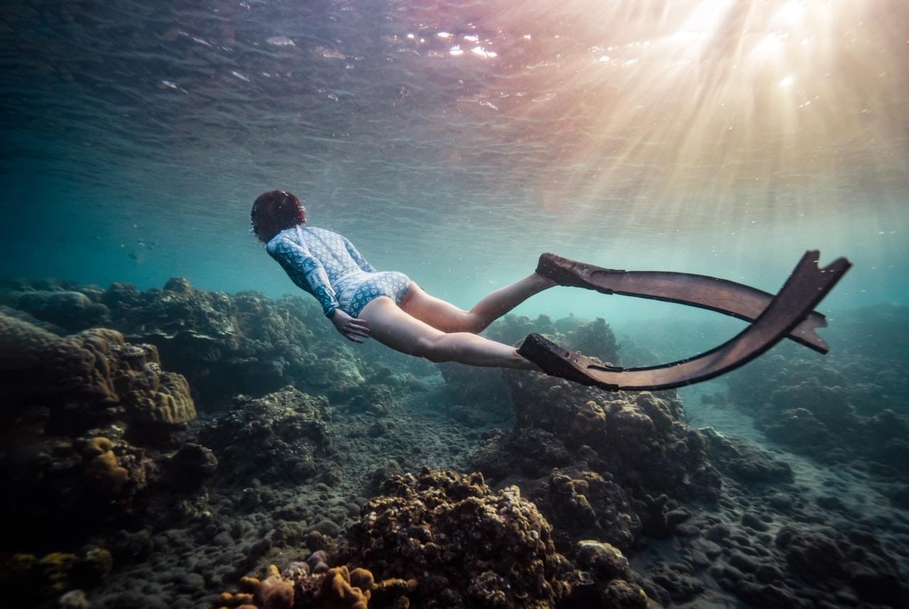 girl snorkeling with freedive fins underwater
