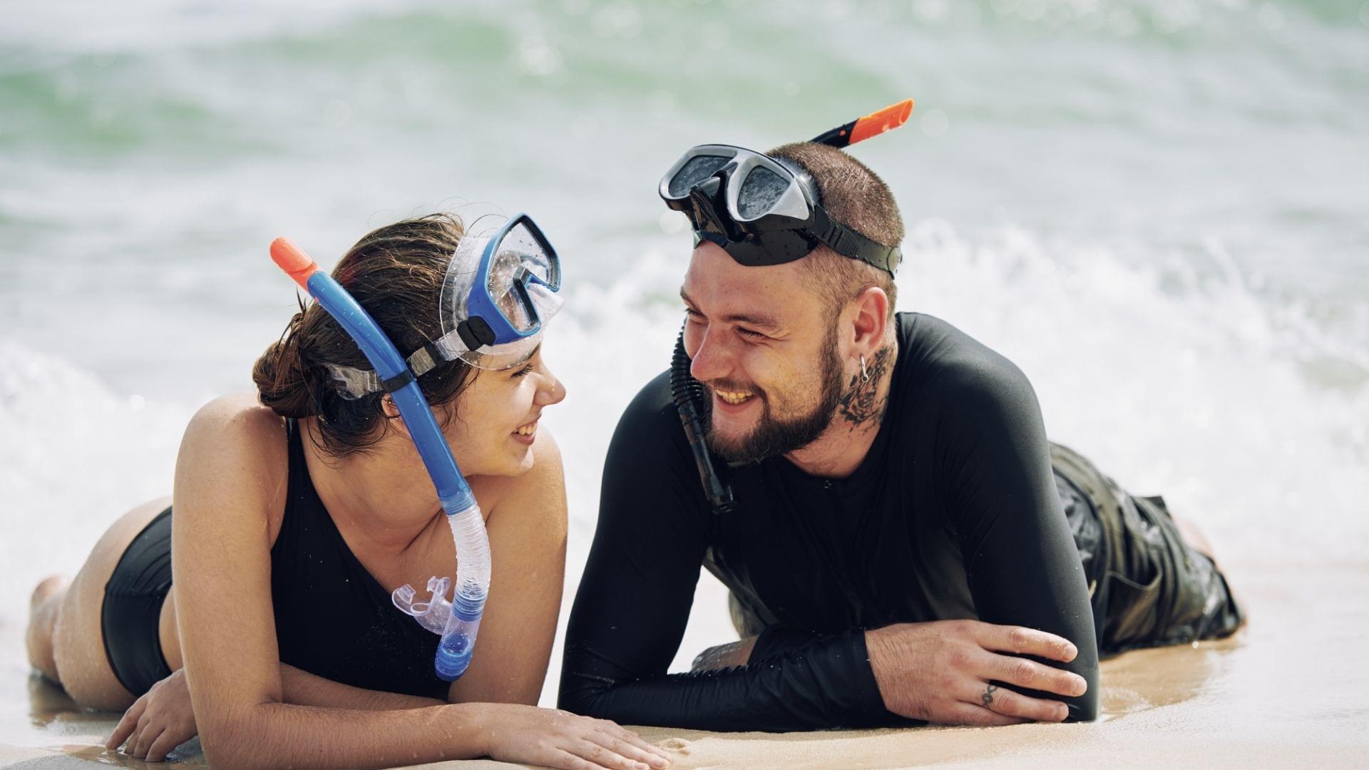 guy and girl on beach with snorkel mask