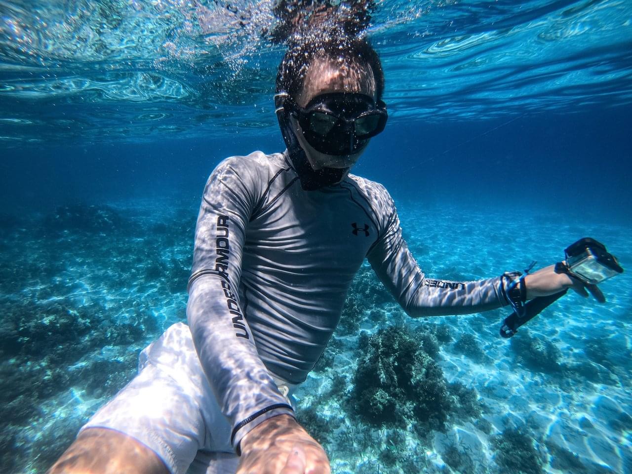 guy underwater with rash guard on