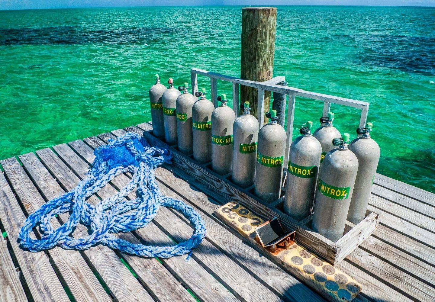 nitrox tanks on dock next to tropical water