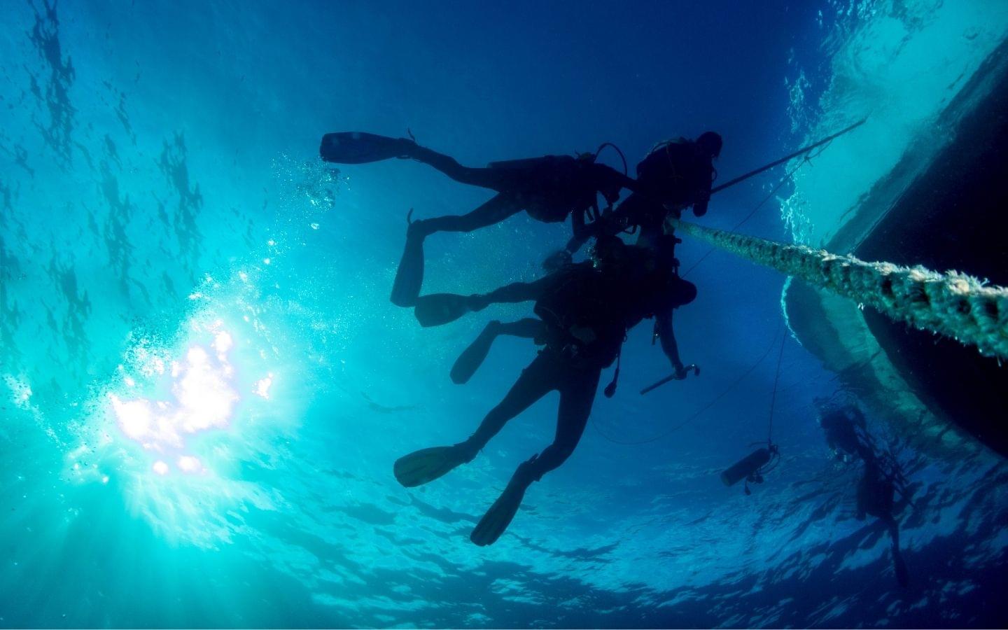 diving underwater on anchor line off boat