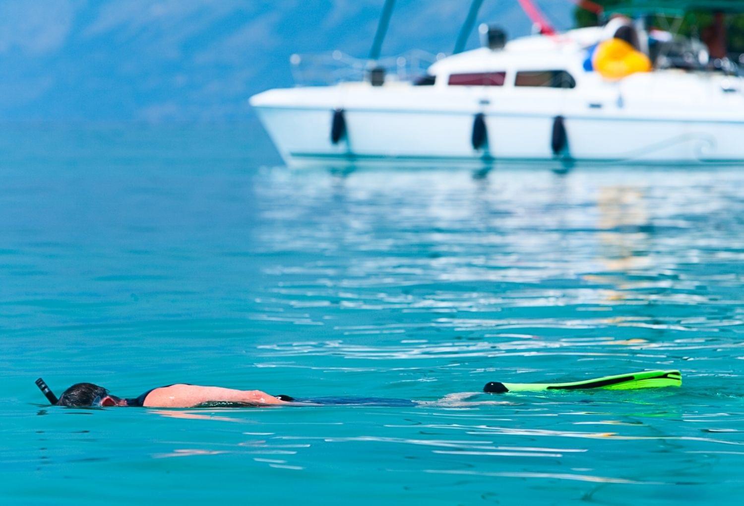 snorkeler next to sail boat in adriatic sea