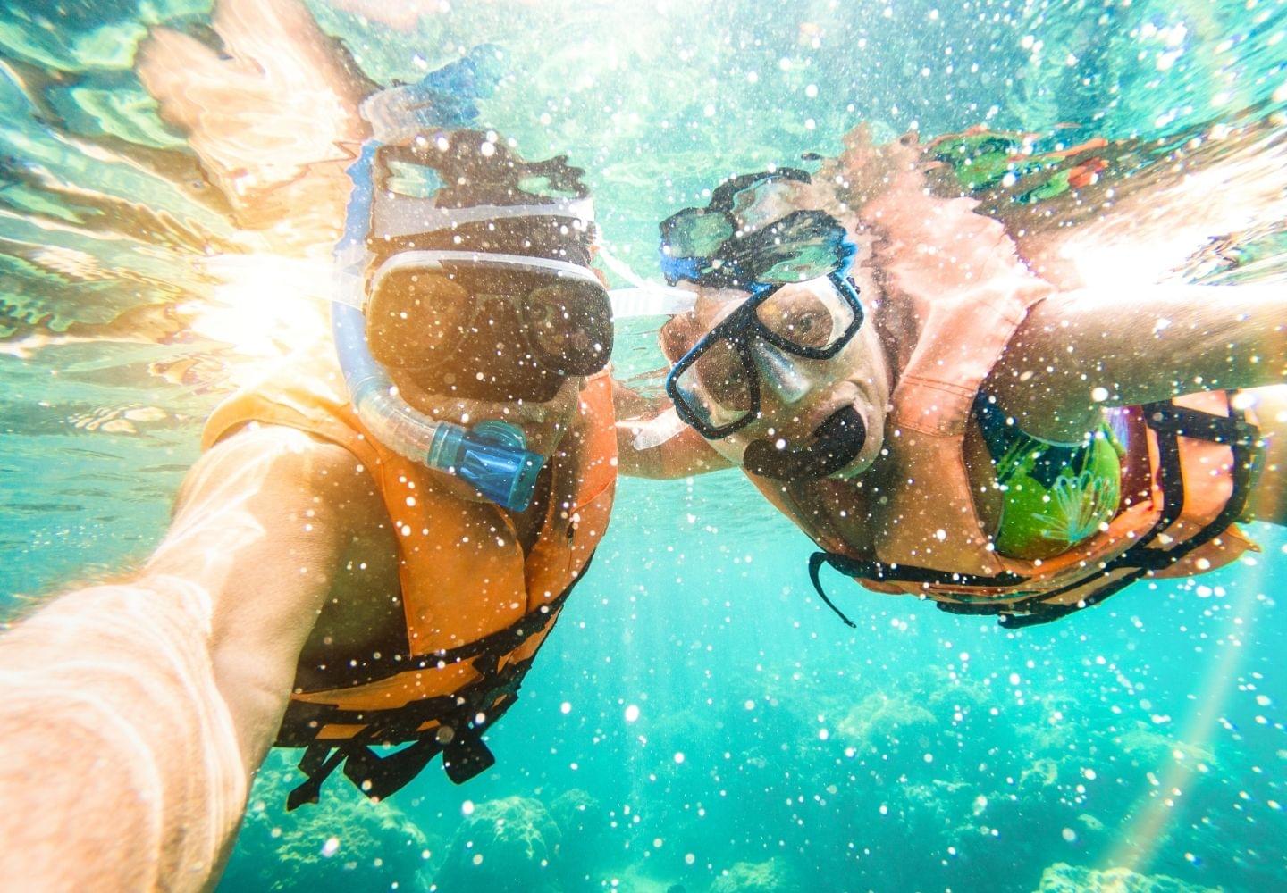 snorkeling couple with life jackets on in water