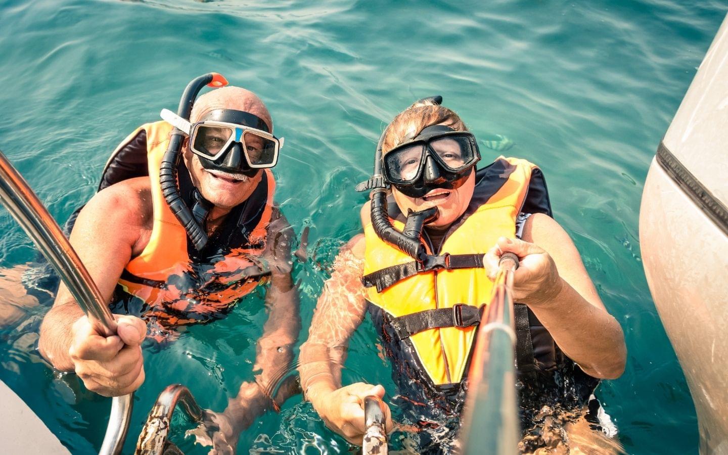 two guys snorkeling with life jackets on