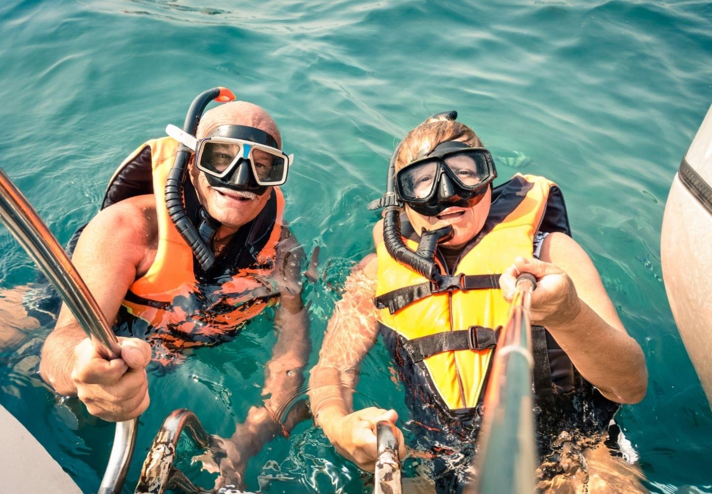 two men snorkeling with life jacket on